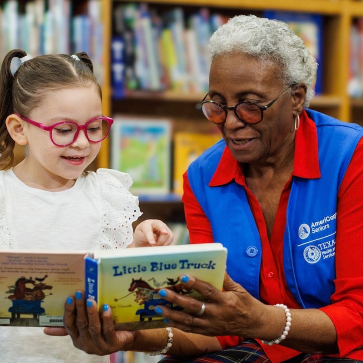 Photo: elementary age girl being read to by "foster grandparent"
